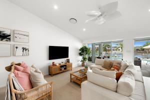 sala de estar con sofá y TV en Exclusive Executive waterfront home, en Mooloolaba