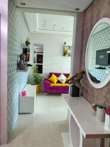 a living room with a purple couch and a mirror at Appartement sidi rahal in Berrechid