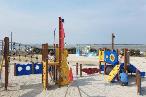 dwójka dzieci bawiących się na placu zabaw w piasku w obiekcie Superbe Studio au Crotoy accès direct plage w mieście Le Crotoy