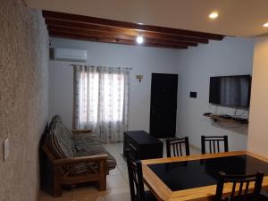 a living room with a couch a table and a tv at Departamento por calle Chile TUNUYAN in Tunuyán