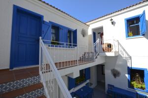 a house with blue doors and a staircase at Cunda Mavi Hotel in Ayvalık