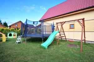 un parque infantil con tobogán y columpio en Holiday resort, Sarbinowo en Sarbinowo