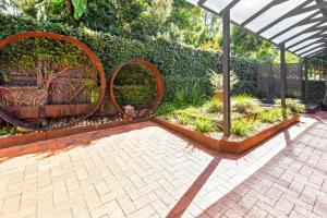 a garden with two large metal sculptures in a pavilion at Unwind at Secret Garden Maleny 3 BR Family Home in Maleny