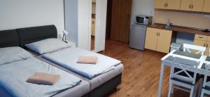 mały pokój z łóżkiem i kuchnią w obiekcie Apartmány Šrámek Stříbro w mieście Stříbro