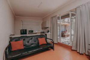 a living room with a couch and a kitchen at Cosy Cottages Guesthouse in Potchefstroom