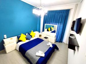 - une chambre avec un lit aux murs jaunes et bleus dans l'établissement Sophie's Guest House, à Vólos