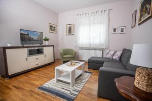 a living room with a couch and a tv at Apartman Gundulić in Vinkovci