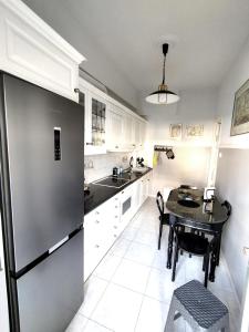 a kitchen with a table and a stainless steel refrigerator at Sophie's Guest House in Volos