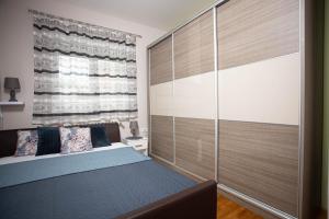 sypialnia z łóżkiem i dużym oknem w obiekcie Apartman Gundulić w mieście Vinkovci