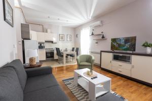 Apartman Gundulić في فينكوفسي: غرفة معيشة مع أريكة وطاولة