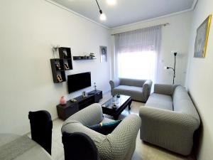 - un salon avec deux canapés et une télévision dans l'établissement Sophie's Guest House, à Vólos