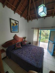 a bedroom with a bed in a room with a window at Finca Jardín del Agua in Sasaima