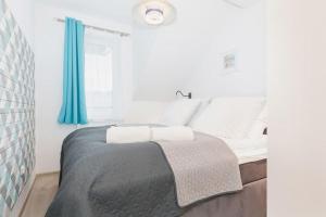 sypialnia z dużym łóżkiem z niebieskimi zasłonami w obiekcie OnHoliday Apartamenty ulica Poleska w Kołobrzegu