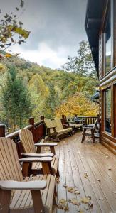a deck with chairs sitting on top of a building at Beautiful 6 bdr cabin with hot tub in the Smokies! in Pigeon Forge