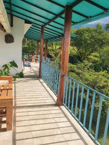 eine Veranda mit einem blauen Geländer und einem blauen Baldachin in der Unterkunft Finca Jardín del Agua in Sasaima