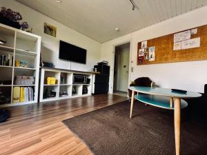 a living room with a table and a tv at Rosengren Residence, Fireplace & barbecue in Billund