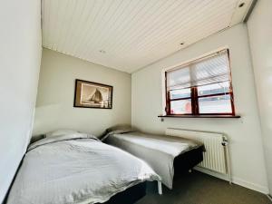 2 Betten in einem Zimmer mit Fenster in der Unterkunft Rosengren Residence, Fireplace & barbecue in Billund