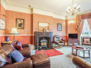 Edderton Hall Country House في Forden: غرفة معيشة مع أريكة ومدفأة