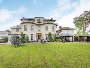 uma casa grande com um relvado em frente em Edderton Hall Country House em Forden