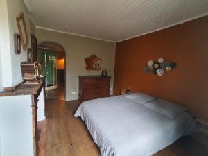 a bedroom with a white bed and a dresser at Très belle maison chaleureuse au coeur de Mirepoix in Mirepoix