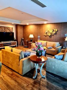 a living room with couches and a table with flowers at Royal Residencia Centaurus in Islamabad