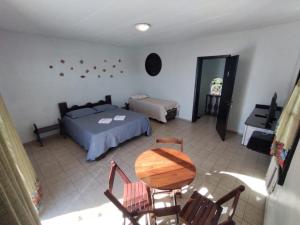 1 dormitorio con 1 cama, mesa y sillas en Pousada Castelinho Caiobá, en Caiobá