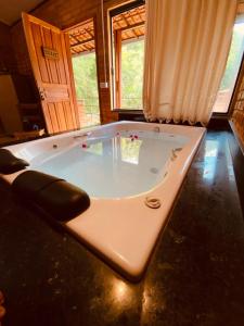 a large bath tub in a room with at Pousada, Camping e Restaurante do Sô Ito in Santa Rita de Jacutinga