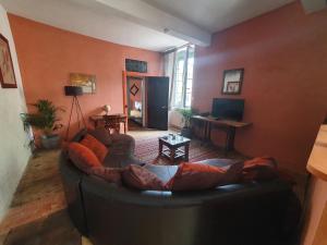 una sala de estar con un sofá negro en una habitación en Très belle maison chaleureuse au coeur de Mirepoix en Mirepoix