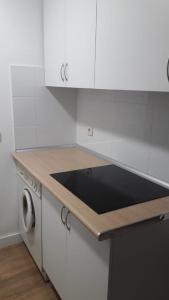 kuchnia z białymi szafkami i czarnym blatem w obiekcie Piso 3 dormitorios junto al metro Nueva Numancia, a 15 min de Sol en metro w Madrycie