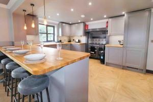 a kitchen with a large island with bar stools at Hear Lions Roar while enjoying a beautiful holiday in Lincolnshire