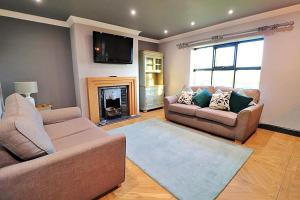 a living room with two couches and a fireplace at Hear Lions Roar while enjoying a beautiful holiday in Lincolnshire