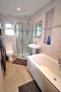 a bathroom with a sink and a tub and a toilet at Hear Lions Roar while enjoying a beautiful holiday in Lincolnshire