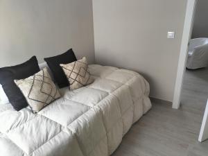um sofá branco com almofadas num quarto em Apartamento zafra Cristina em Zafra