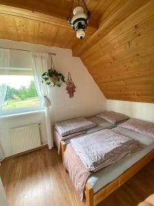 2 łóżka w pokoju z drewnianym sufitem w obiekcie Agroturystyka Pod Modrzewiem w Zubrzycy Górnej