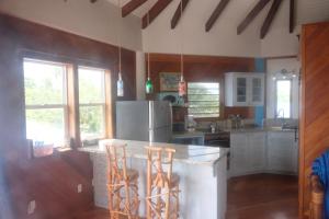 a kitchen with a counter and two stools at Moonrise Beach in Placencia Village