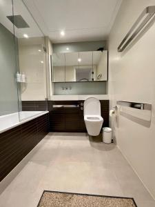 a bathroom with a toilet and a sink and a mirror at Battersea Power Station Living in London