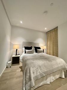 Un dormitorio con una cama grande y una ventana en Battersea Power Station Living, en Londres