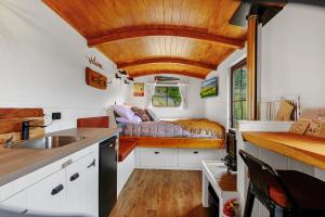a kitchen with a bed in a tiny house at The Shepherds Hut - boutique retreat. in Hanmer Springs