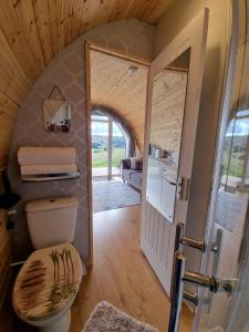 a small bathroom with a toilet and a doorway at Forester's Retreat Glamping - Dinas View in Aberystwyth