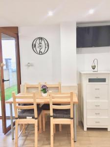 a dining room with a wooden table and chairs at APARTAMENTO Luis in Suances +5 photos