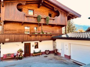 a large wooden house with a garage at Natural Deluxe Apartments Alpbach in Alpbach