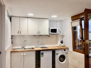 a kitchen with a sink and a washing machine at APARTAMENTO Luis in Suances