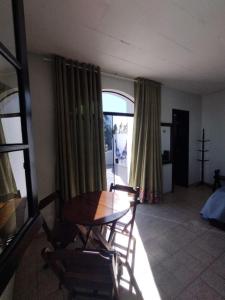 a dining room with a table and chairs and a window at Pousada Castelinho Caiobá in Caiobá