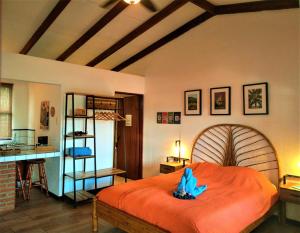 Un dormitorio con una cama grande con una criatura azul. en Orosi Lodge en Orosí