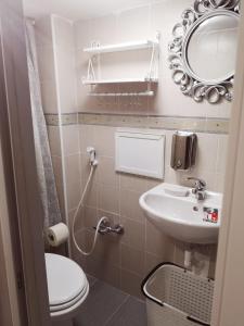 a bathroom with a toilet and a sink and a mirror at the lighthouse accommodation in Taranto