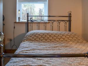 a bed sitting in a room with a window at Primrose Cottage - Uk41346 in Cromer