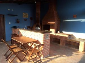 un patio con mesa, sillas y horno de ladrillo en Casa Brasil pousada e lazer en Trindade
