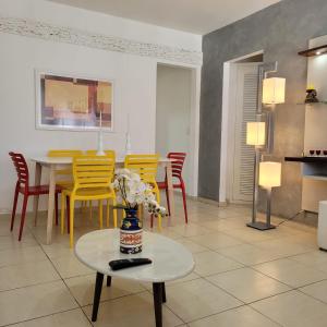 un soggiorno con tavolo e sedie gialle di Geriba Apart Hotel a Búzios