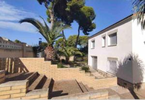 un edificio blanco con escaleras y una palmera en Casa la Pineda Salou, playa y Port Aventura, en Salou