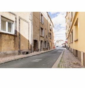 una strada vuota in una città con edifici di Location F1 neuf centre historique Riom (63) - Puy-de-Dôme, Auvergne a Riom